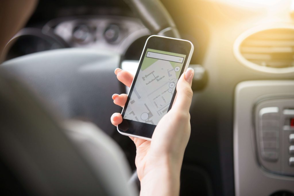 Kierowca korzysta z mapy na smartfonie - jak działa kalkulator OC UNIQA